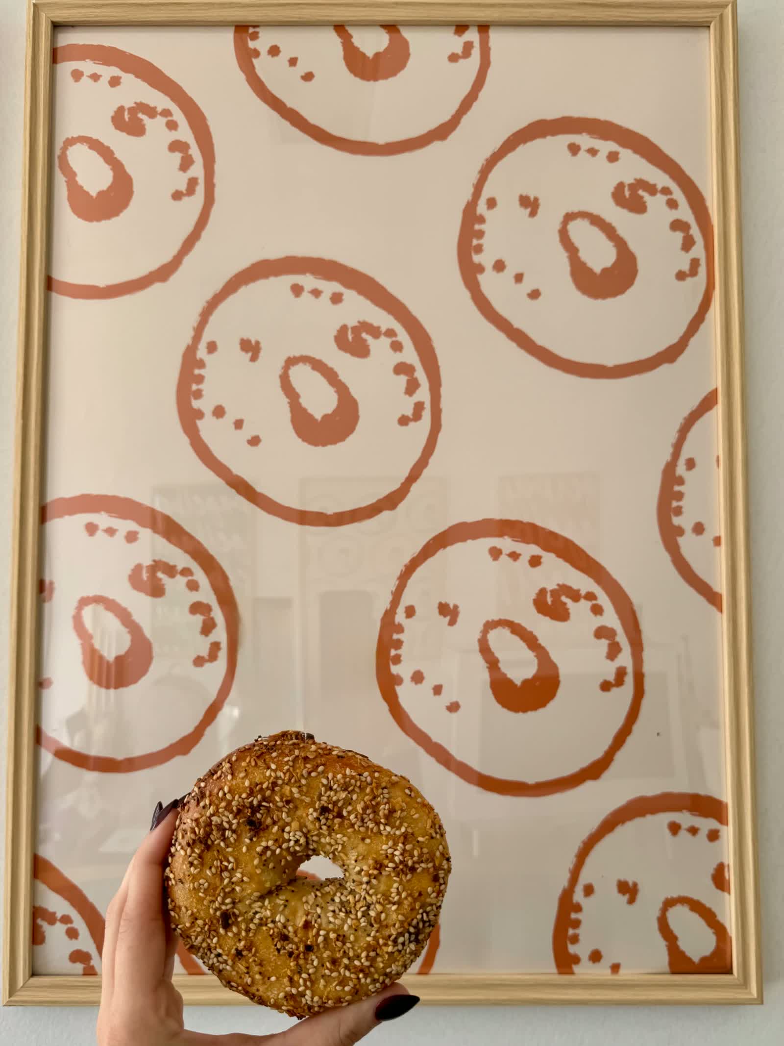 a bagel held up in front of the bagel bagel wall print